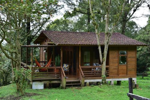 a cabin in the woods with a wrap around porch at Condominio Hacienda Shangrila in San Francisco