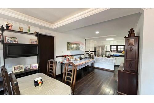 a dining room with a table and a kitchen at Casa Indaiá in Petrópolis