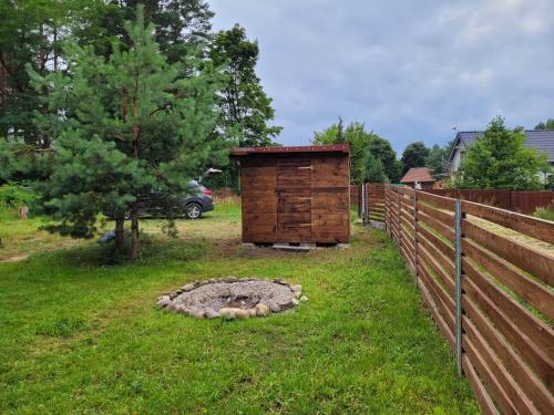 a wooden outhouse in a yard next to a fence at Domek dla dwojga in Pelnik