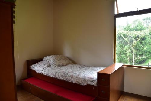 a small bedroom with a bed and a window at Condominio Hacienda Shangrila in San Francisco
