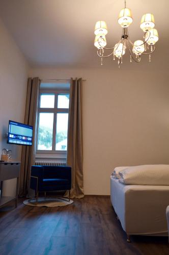 a bedroom with a bed and a window and a chandelier at Cafe Zentral, Zimmer mit Frühstück in Kötschach