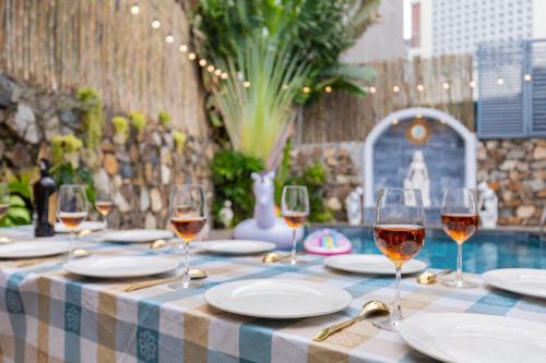 头顿Sun Villa 33 Phan Huy Ích - Phòng Khách Có Máy Lạnh的桌子上摆放着酒杯的桌子