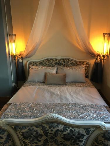 - un lit avec deux lumières au-dessus dans l'établissement L Ancien Four à Pain, à LʼÉglise-aux-Bois