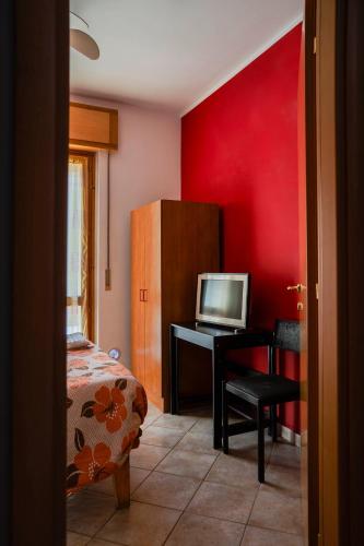 a bedroom with a bed and a desk with a television at La Casa Zen in San Giovanni Teatino