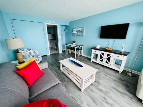a living room with a couch and a flat screen tv at Endless Ocean View Beachfront 1131 in Myrtle Beach