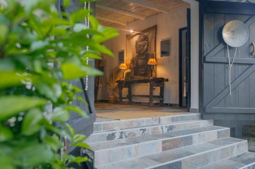 a front door of a house with a statue on a table at La VILLA BORAHA 300m2 PROPRIÉTÉ ENTIERE en bord de plage PISCINE PRIVEE Cuisine TV Wifi in Sainte Marie