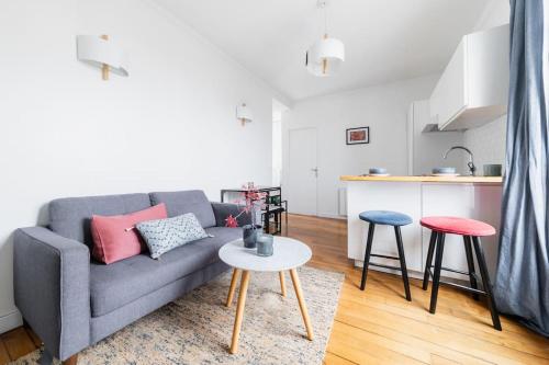 - un salon avec un canapé, une table et deux tabourets dans l'établissement Super Apt Tolbiac-buttes Cailles, à Paris