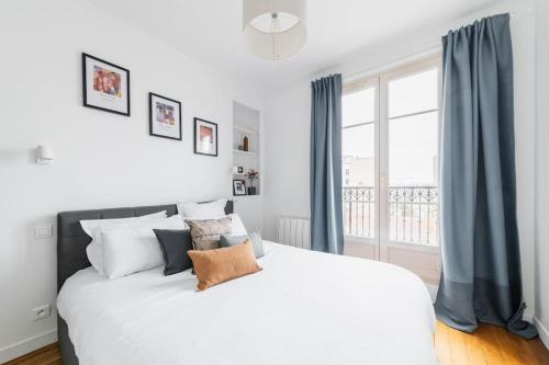 une chambre avec un grand lit blanc et une fenêtre dans l'établissement Super Apt Tolbiac-buttes Cailles, à Paris