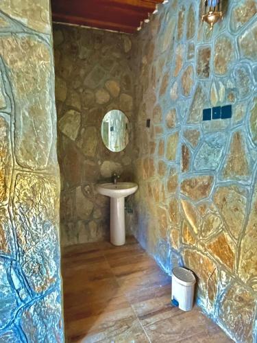 a bathroom with a sink and a stone wall at bait bimah travel lodge in Bīmah