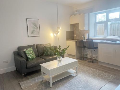 a living room with a couch and a table at Dream Yard Apartments in Southend-on-Sea