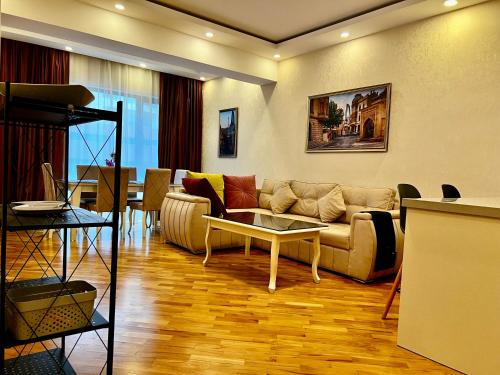 a living room with a couch and a table at Park Azure 0900 in Baku