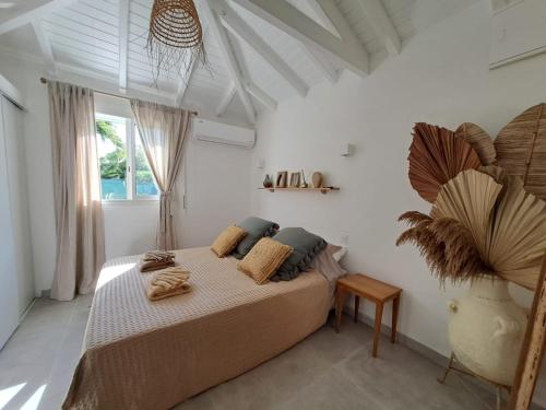 a bedroom with a bed with pillows on it at Sweet Cane Tiny House & Pool in Saint-François