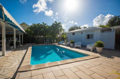 a swimming pool in the backyard of a house at Sweet Cane Tiny House & Pool in Saint-François