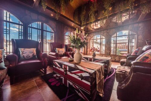 a living room with a couch and chairs and a table at Gucheng Lanshe Designer Garden B&B in Lijiang