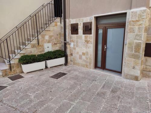 un ingresso a un edificio con porta e piante di Borgo Sant'Antonio a Santeramo in Colle