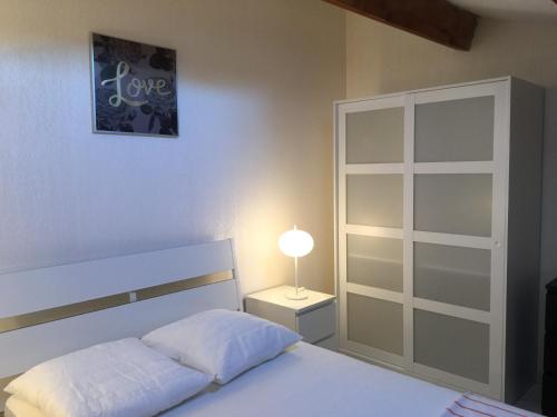- une chambre avec un lit et une lampe sur une table de chevet dans l'établissement Residence Enzo Paradise, à La Seyne-sur-Mer