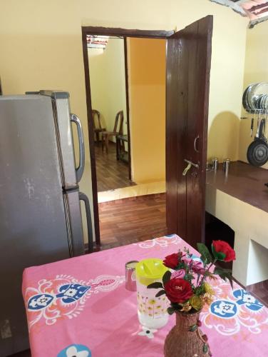a table with a pink table cloth with a vase of flowers at The Grace 2BHK Holiday Home in Benaulim