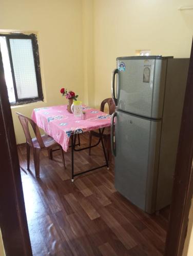 a kitchen with a table and a refrigerator at The Grace 2BHK Holiday Home in Benaulim