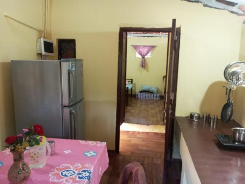 a kitchen with a pink table and a refrigerator at The Grace 2BHK Holiday Home in Benaulim
