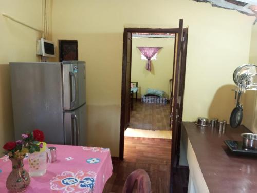 a kitchen with a table and a refrigerator at The Grace 2BHK Holiday Home in Benaulim