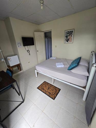 a bedroom with a large white bed in a room at La Casa Las Palmitas in Penonomé