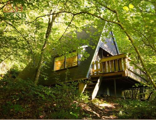 una casa con terraza en el bosque en The Forest Cabin Durbuy, en Durbuy