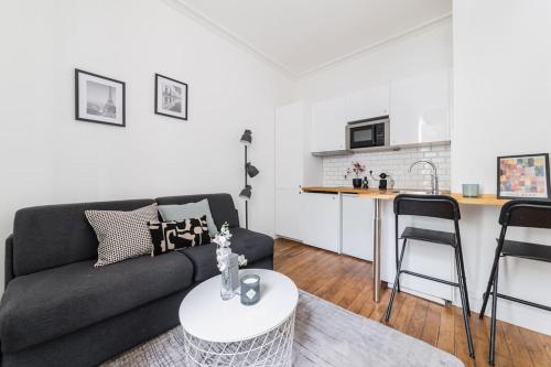 un salon avec un canapé et une cuisine dans l'établissement Studio Tolbiac, à Paris