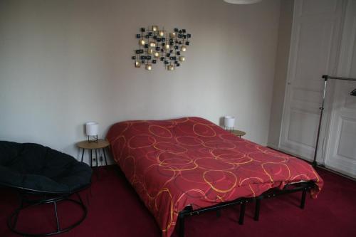 - une couverture rouge sur un lit dans l'établissement T2 centre ville de Dreux - Entrée autonome, à Dreux