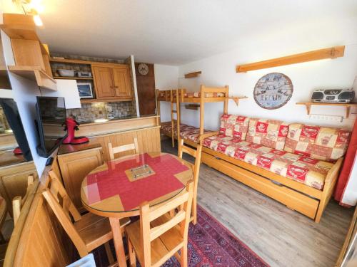 Cette petite chambre comprend une table et des lits superposés. dans l'établissement Résidence Combes - Studio aux pieds des pistes aux Menuires avec vue panoramique MAE-3984, aux Menuires