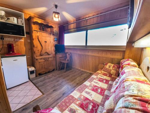 une chambre avec un lit dans une pièce avec une fenêtre dans l'établissement Résidence Combes - Studio style chalet au pied des piste MAE-4044, aux Menuires