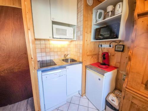 une petite cuisine avec un évier et un réfrigérateur dans l'établissement Résidence Combes - Appartement aux pieds des pistes aux Menuires avec ve panoramiqe MAE-4084, aux Menuires