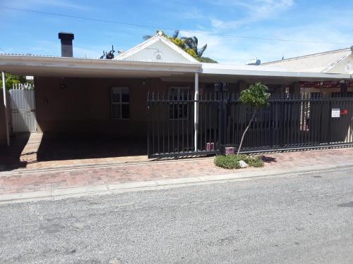 a house with a fence on the side of the street at Tolbos Backpackers in Worcester