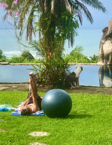 a woman laying on the grass next to a ball at Casa Vista Pacifico in Esterillos