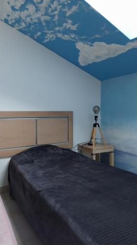 une chambre avec un grand lit avec un plafond bleu dans l'établissement Chez Twin&Twin, à Santa-Maria-Poggio