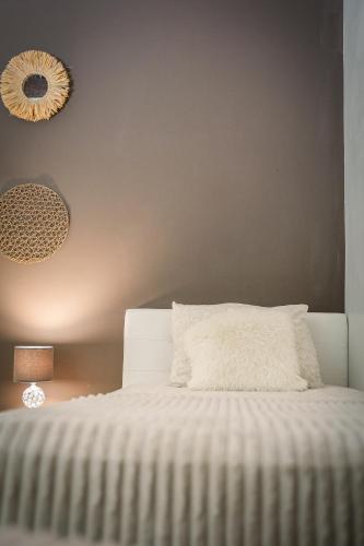 a bedroom with a white bed and a lamp at Gîte la casa del cookie in Chimay
