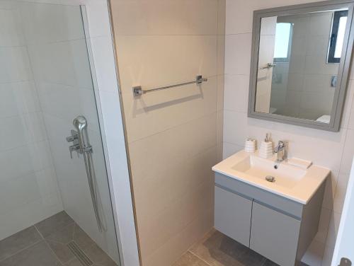 Un baño con lavabo y ducha en Ocean Luxury Penthouse, en Kalogrea