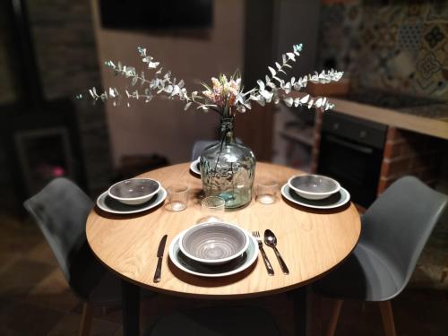 a table with plates and a vase of flowers on it at Villa pose in Robledillo