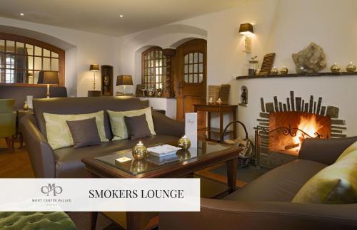 a living room with a couch and a fireplace at Mont Cervin Palace in Zermatt