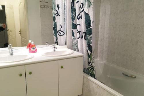 La salle de bains est pourvue de 2 lavabos et d'un rideau de douche. dans l'établissement Disneyland Paris apartment terrasse & parking 343, à Serris