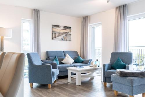 a living room with two blue chairs and a couch at Seaside 49 3 N in Wangerland