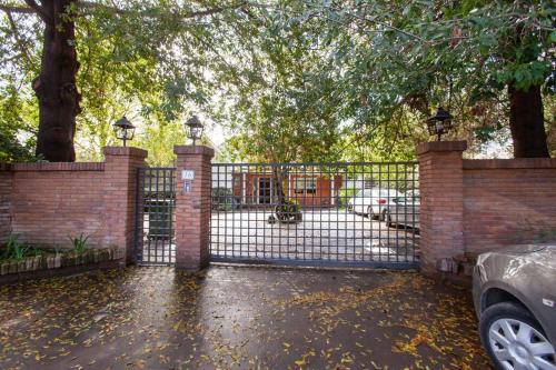 a wrought iron fence with a gate in a yard at Escape al bosque! - Casa Vintage in San Luis