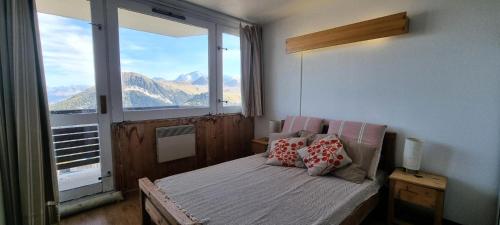 une chambre avec un lit avec une grande fenêtre dans l'établissement Résidence Diamant - 3 Pièces pour 7 Personnes 361, à Aime La Plagne