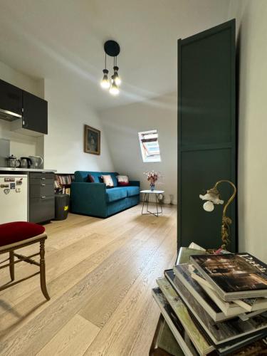 un salon avec un canapé bleu et une table dans l'établissement Cosy Studio 5 minutes Tour Eiffel, à Paris