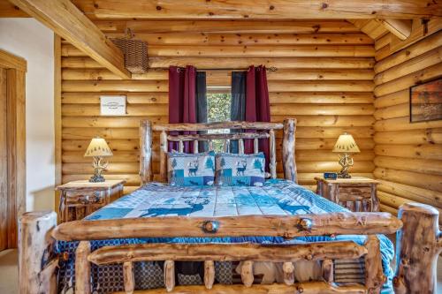 Un dormitorio con una cama en una cabaña de troncos en Overlook at Sleepy Creek -- Sleepy Creek Frontage, Secluded, Grill, Fire Pit, Deck, Family Friendly, Game Room, Fishing, Hammock, View, Fireplace, en Morton Grove