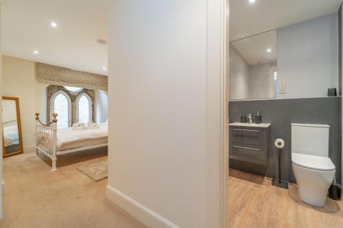 a bathroom with a toilet and a sink and a bed at Edinburgh Church Apartments in Edinburgh