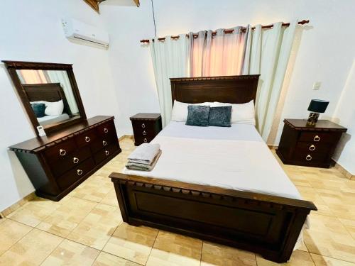 a bedroom with a large bed and a mirror at Apartamento Brisas de la Montaña in Jarabacoa