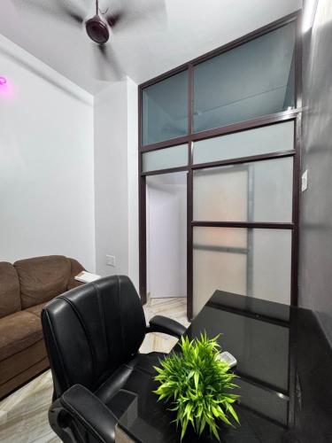 a living room with a black chair and a table at Lake stays in Kolkata