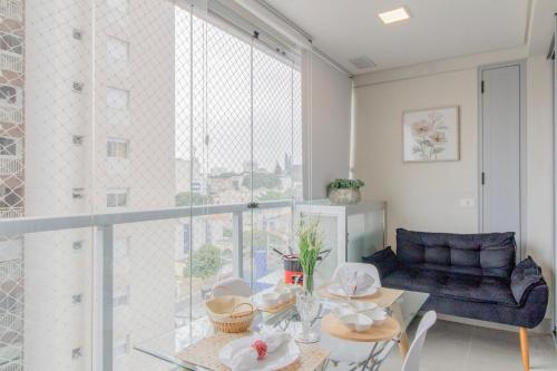 a living room with a table and a large window at 0809 - Sofisticação e Conforto em um Só Lugar in Guarulhos