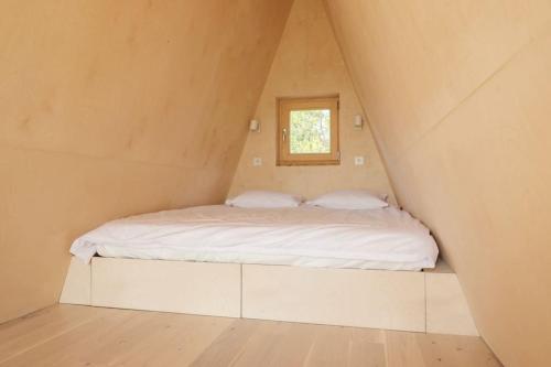 a bed in a small room with a window at Minimalistyczny domek przy Kampinosie in Przęsławice