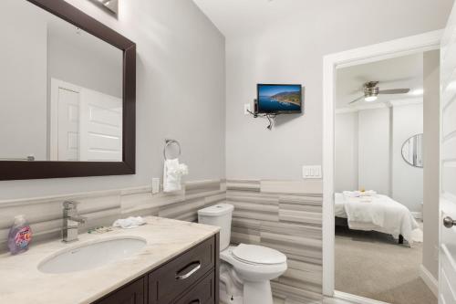 a bathroom with a sink and a toilet and a tv at Lavish 1BR with Pool & Gym Access in Philadelphia